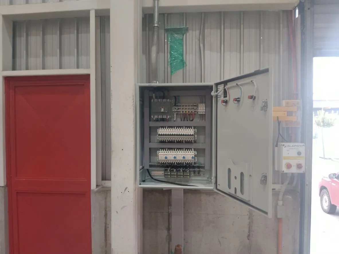 Tablero de alimentación para cargadores de grúas horquilla montado en muro de planta industrial